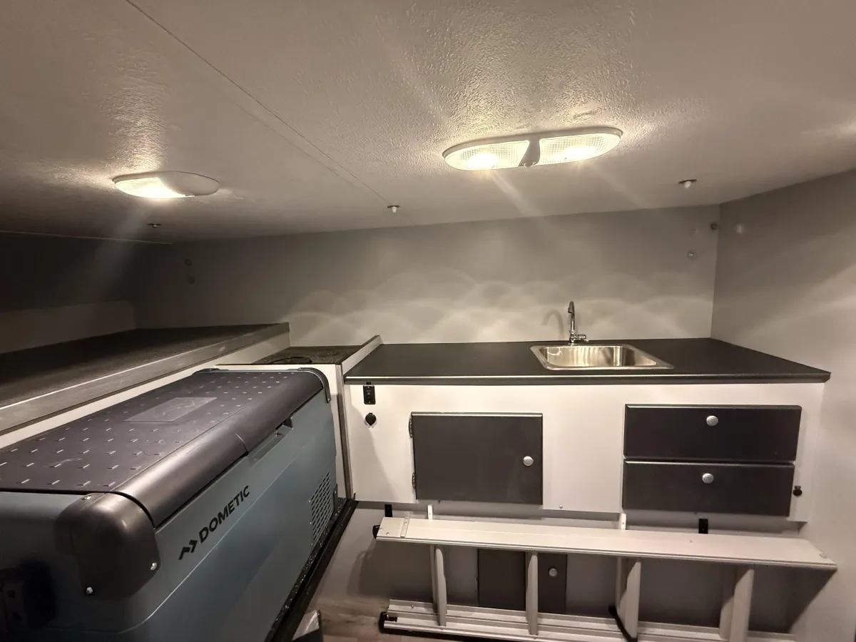 Riptide camper interior kitchen area with sink, countertop, storage drawers, and Dometic fridge