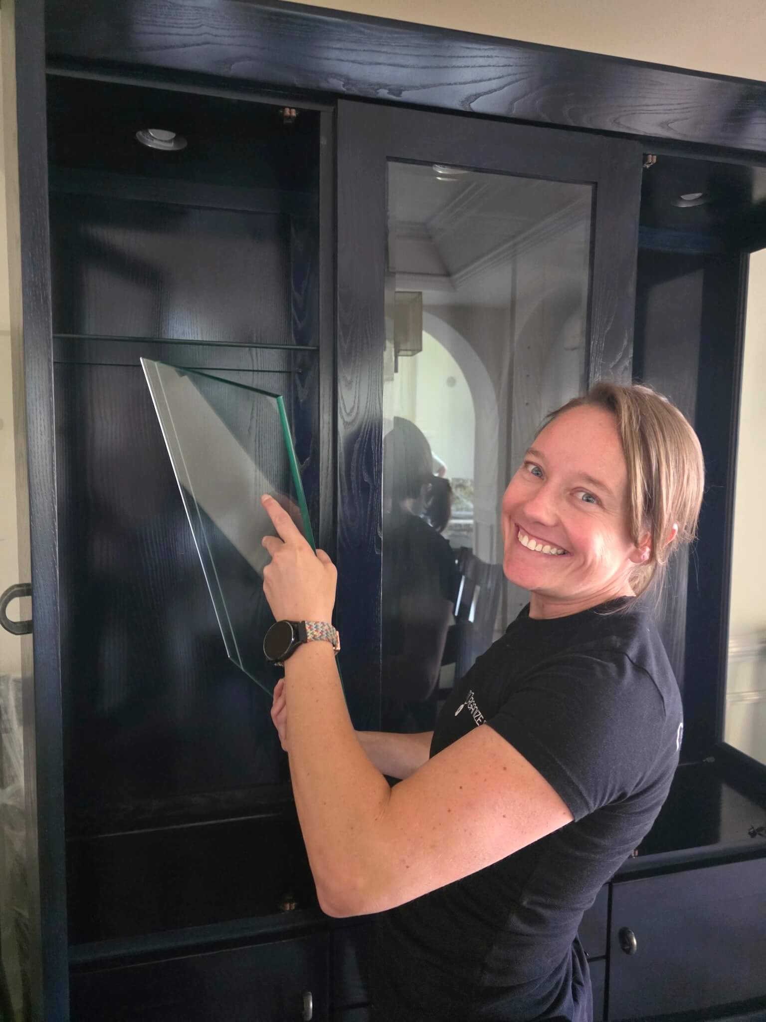 Picture of owner unpacking and placing glass shelf in china cabinet