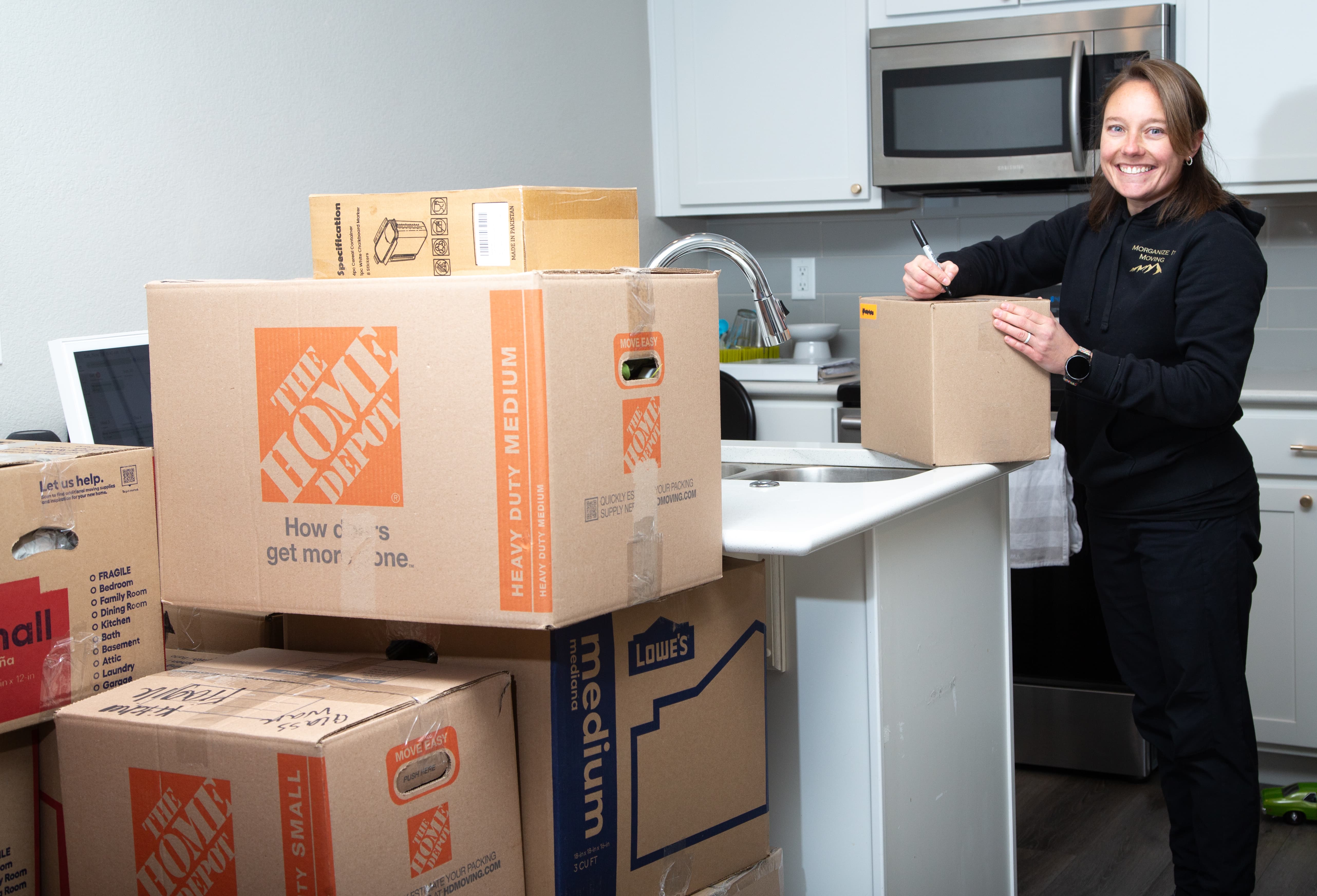 Photo of owner packing fragile items for a moving client