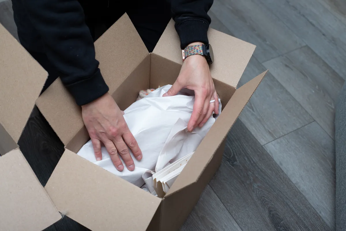 Photo of owner packing fragile items for a moving client
