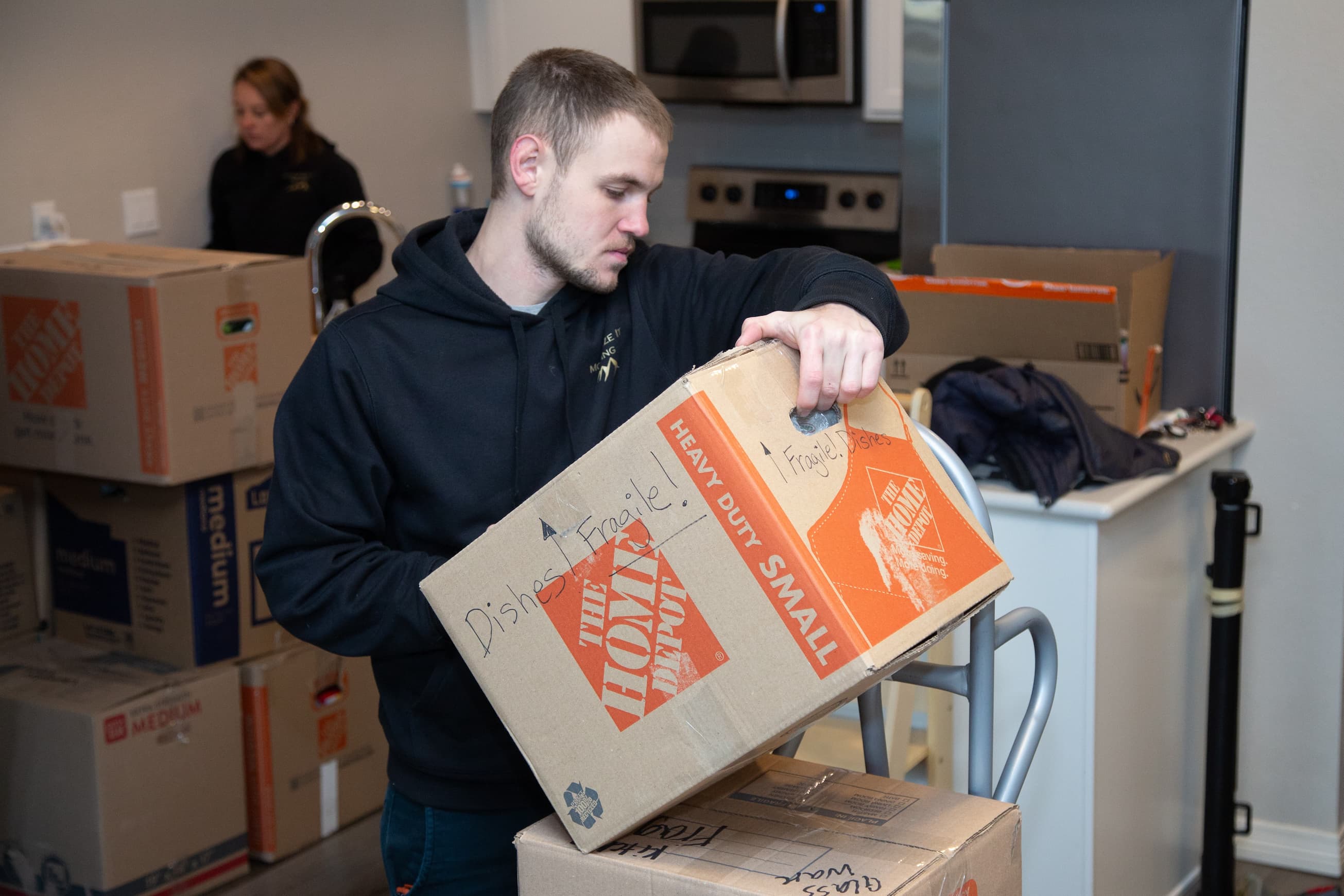 Photo of moving employee carefully placing a box onto a dolly