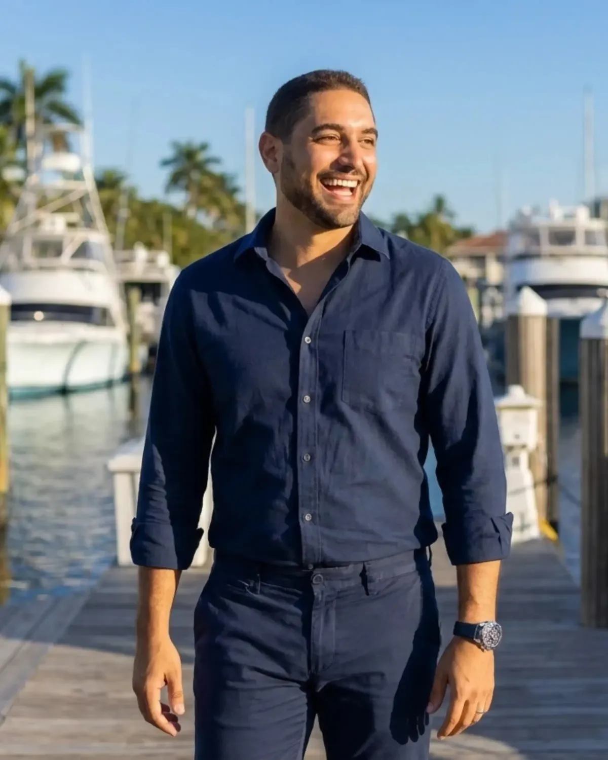 Evan Enisman smiling at a marina, financial advisor and CPA, walking along a dock with boats in the background