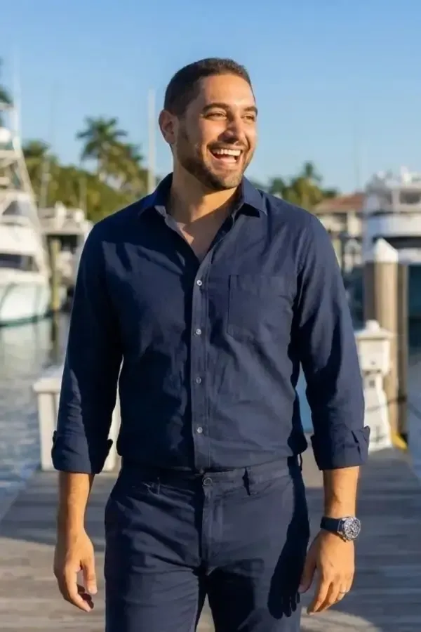 Portrait of Evan Enisman, CPA and tax strategist, standing in a modern office and smiling