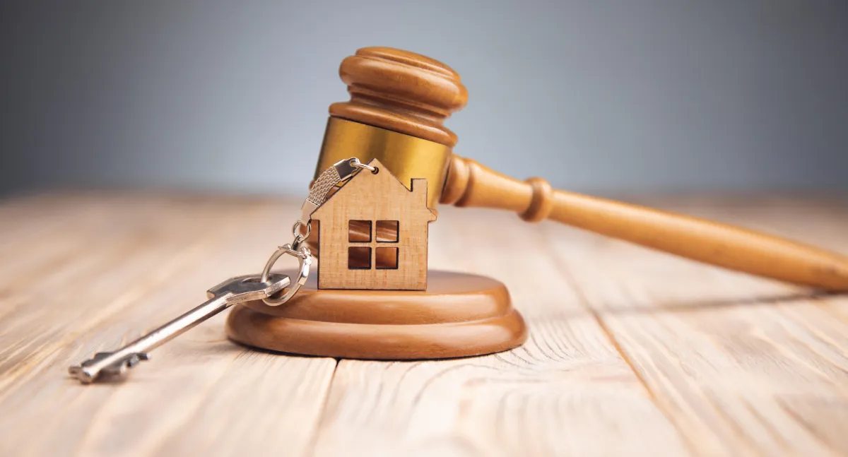 gavel with a little wooden house and key