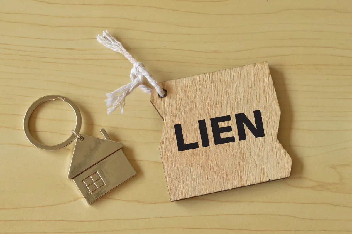 little house key chain next to the word lien