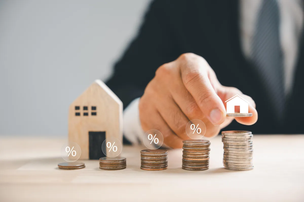 stacks of coins leading to a little house 