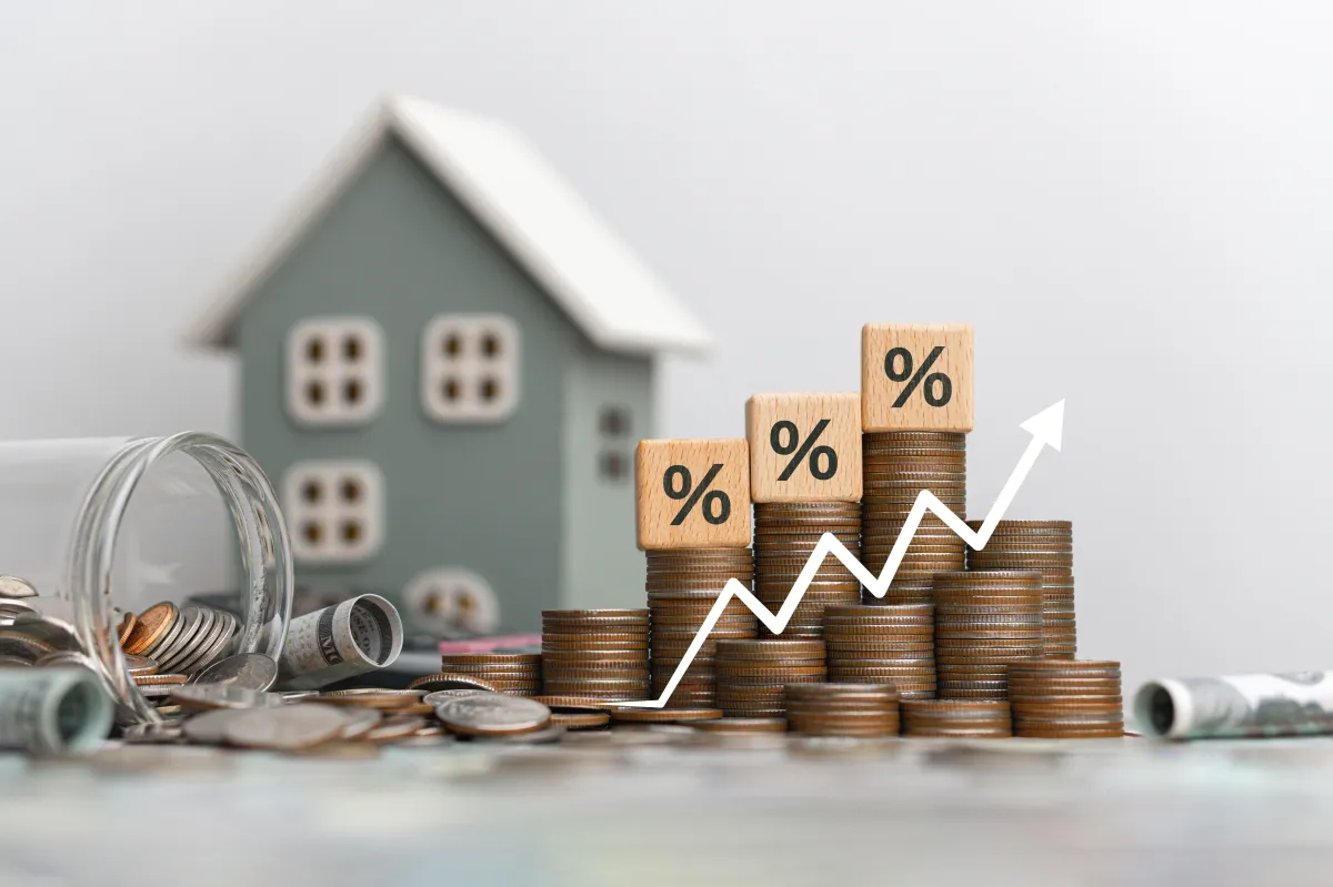 stacks of coins with % in front of house
