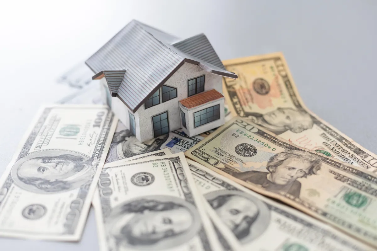 model house with money surrounding it