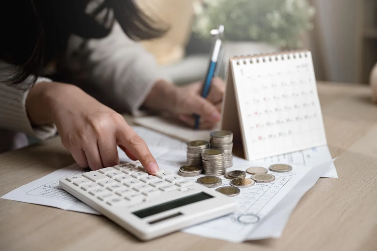 woman with calculator, coins, and calendar