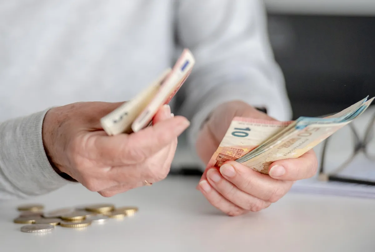 person holding cash and counting it