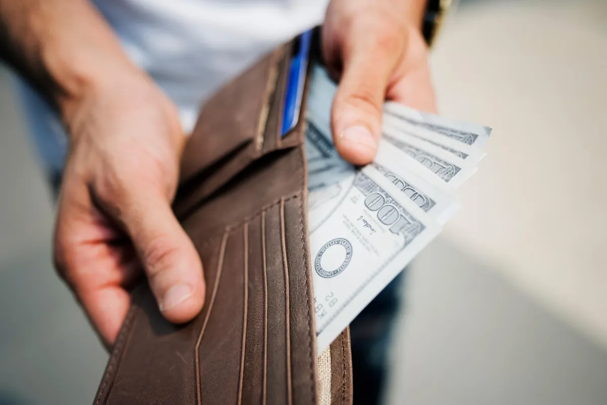 man opening wallet to show cash
