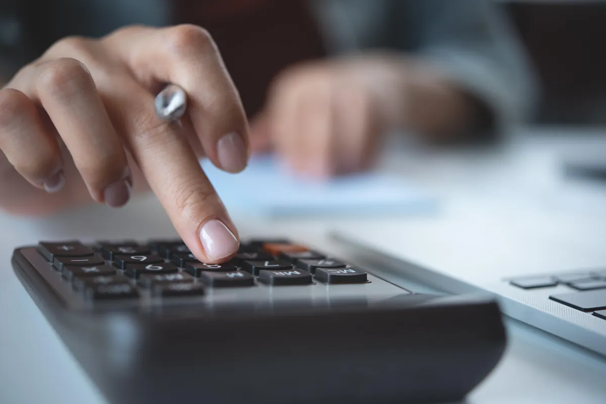 person typing on calculator
