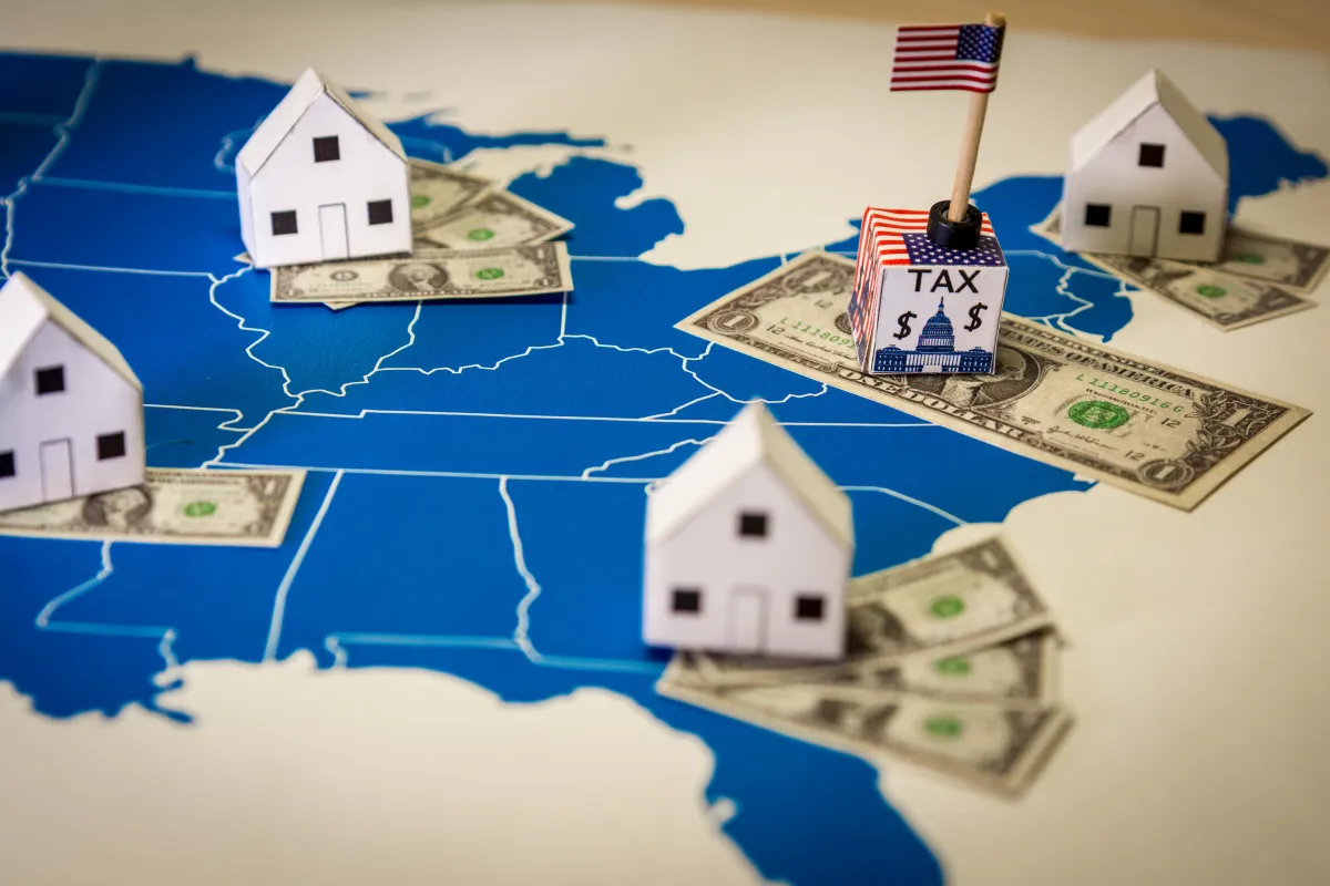 map of US with toy houses sitting on money