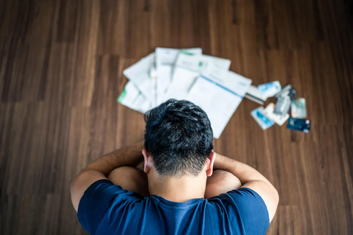man sitting on floor with papers around him 
