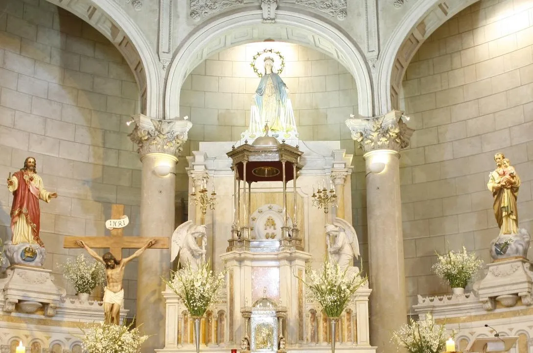 The ceiling of a large building with lots of windows