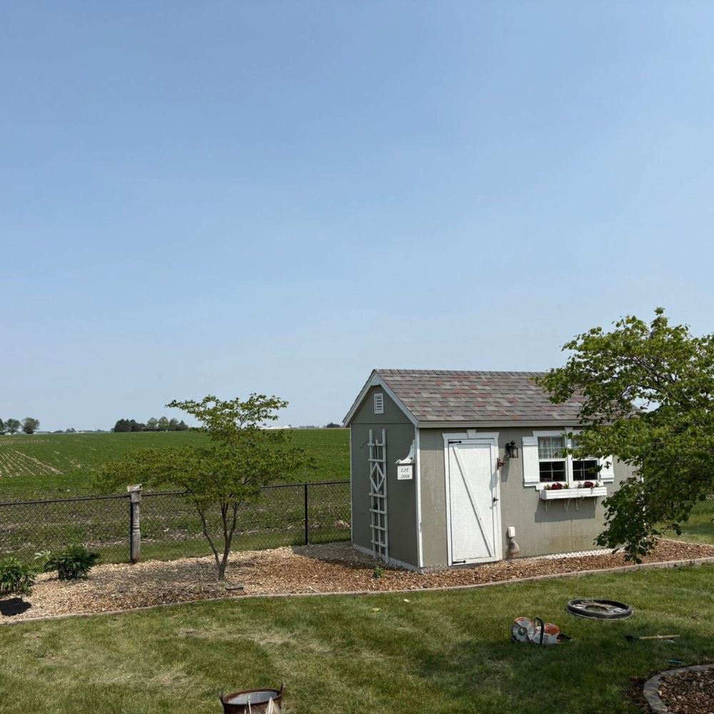 Rock installation in Kalona Iowa around shed creating clean and low maintenance landscape