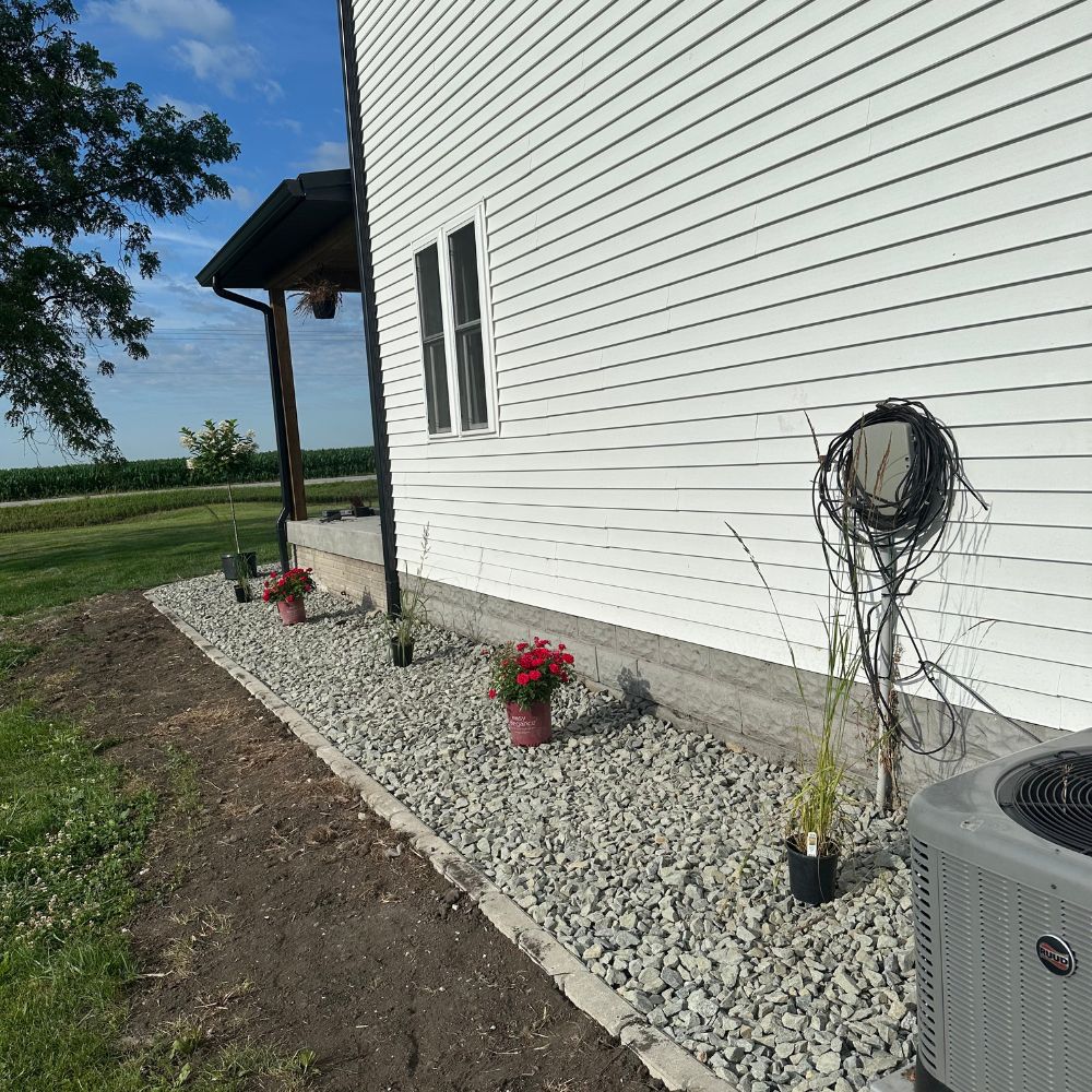 Landscape bed installation in Iowa City Iowa along side yard with rock and edging