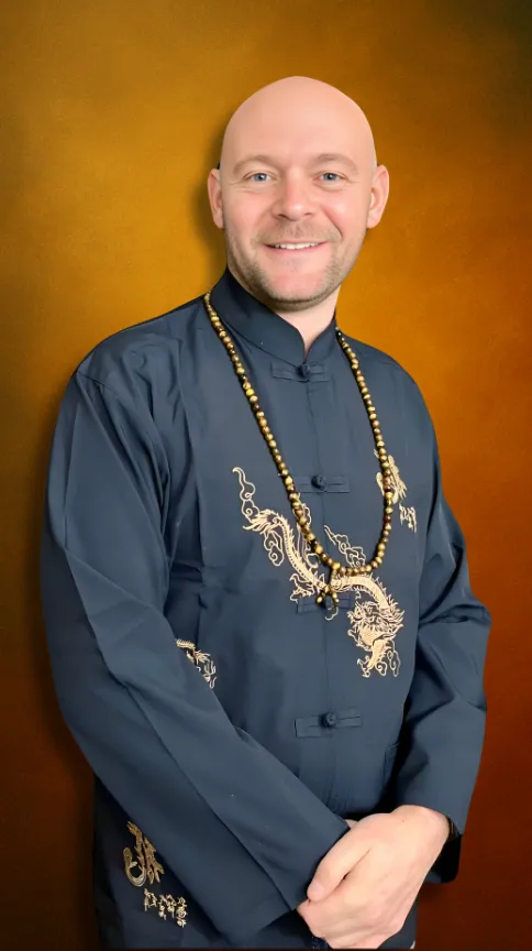 Baz Porter embodying transformational leadership and spiritual empowerment through RAMS By Baz, wearing traditional attire against a golden backdrop symbolizing strength and renewal.
