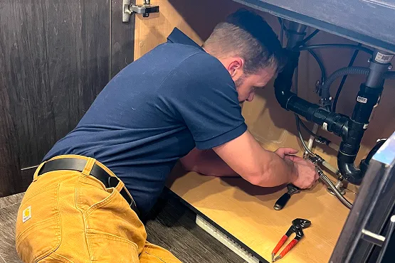 Plumber in front of van.