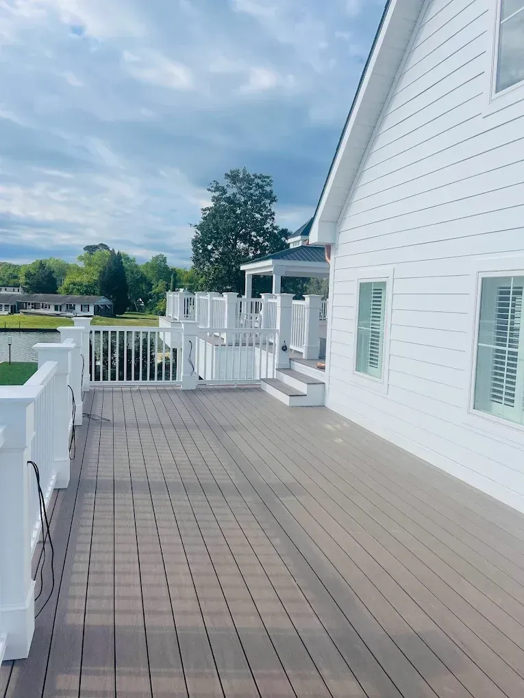 Deck and railing of a modern home with white siding, showcasing a spacious outdoor area, ideal for painting and maintenance services by Victory Painting LLC.