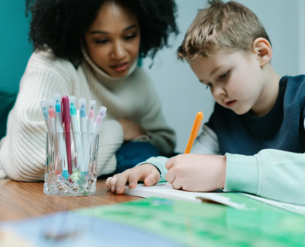 young child writing on a notebook