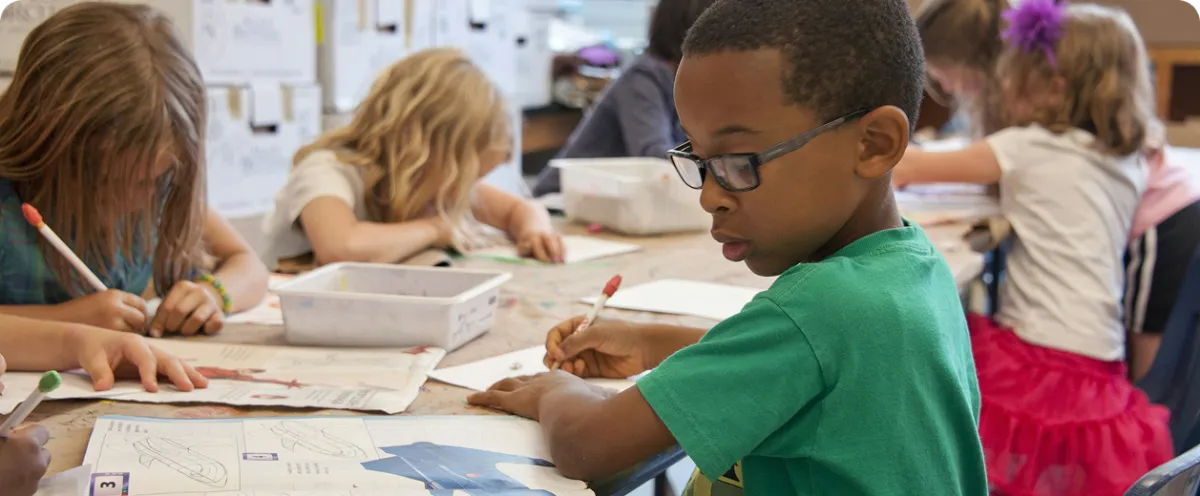 young child writing on a notebook