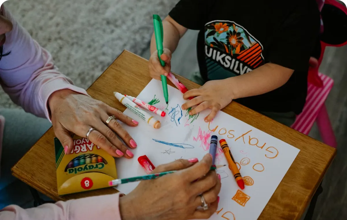 young child writing on a notebook