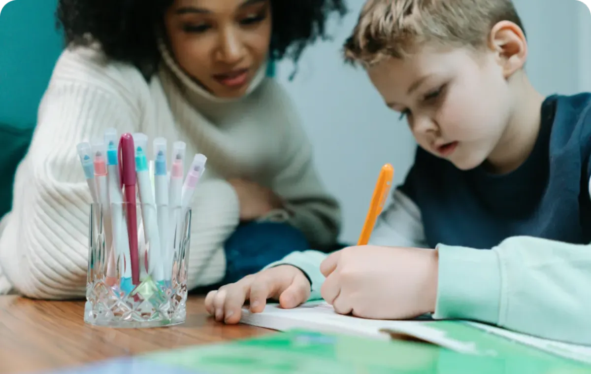 young child writing on a notebook