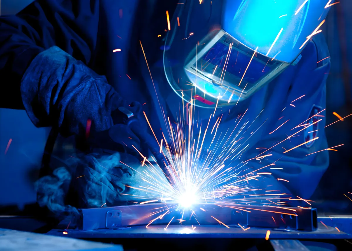 Person welding metal with bright sparks flying.