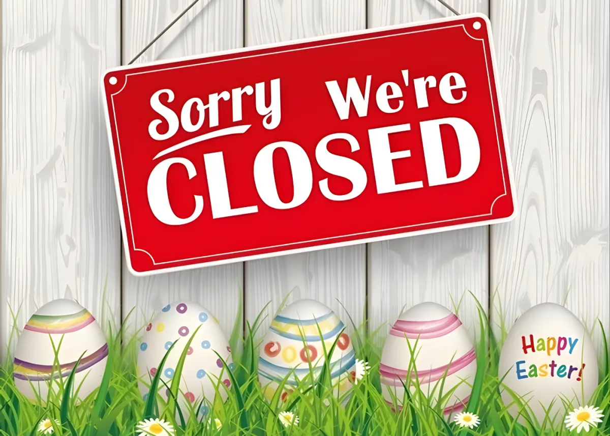 “Sorry we’re closed” Easter sign with decorated eggs in grass.