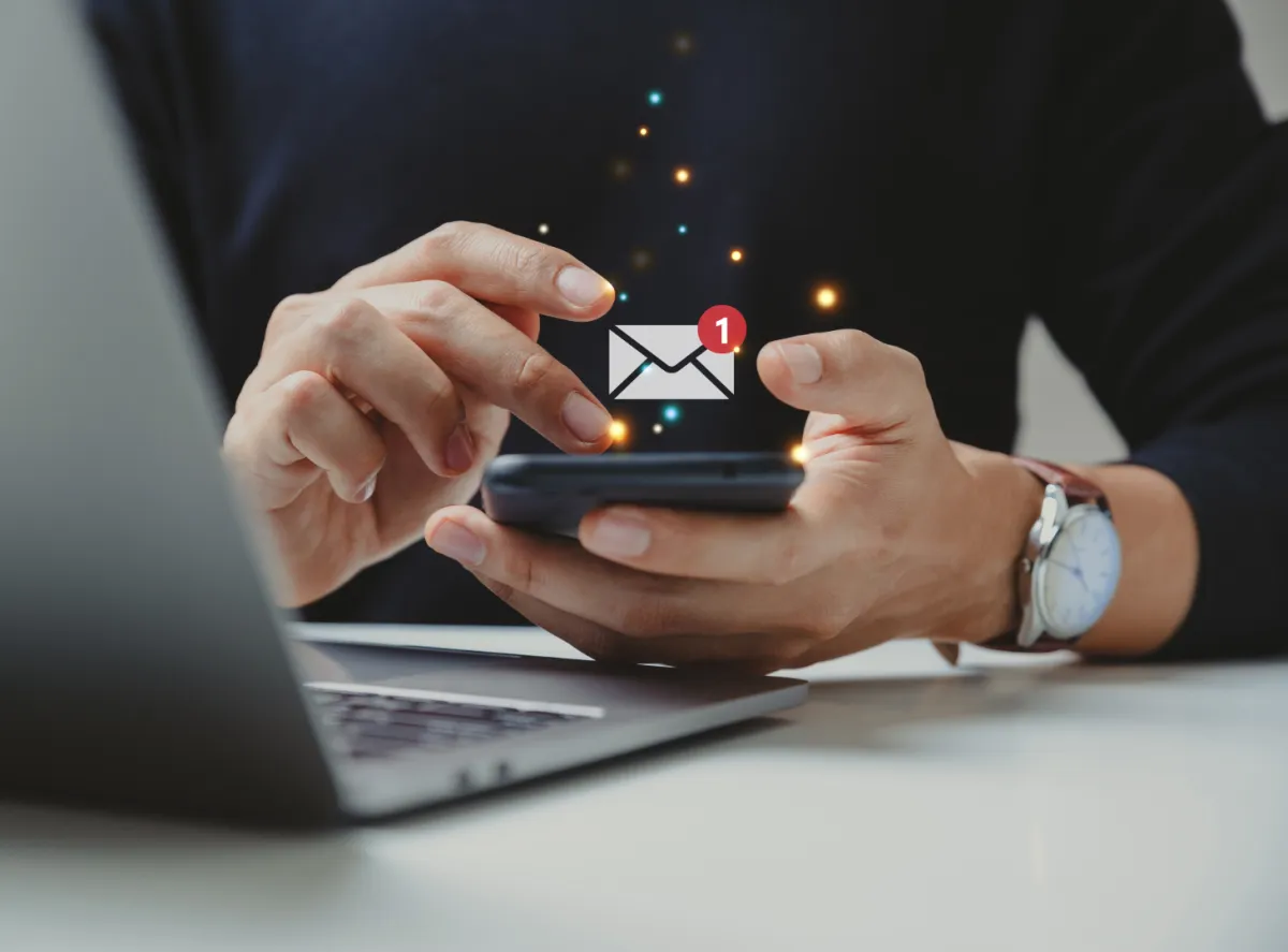 Man holding phone receiving newsletter notificaiton