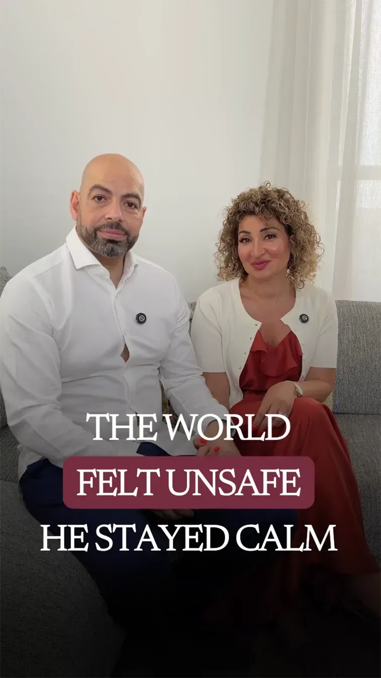 Ramy and Fatima seated side by side on a grey sofa, both looking directly into the camera with calm, steady expressions.