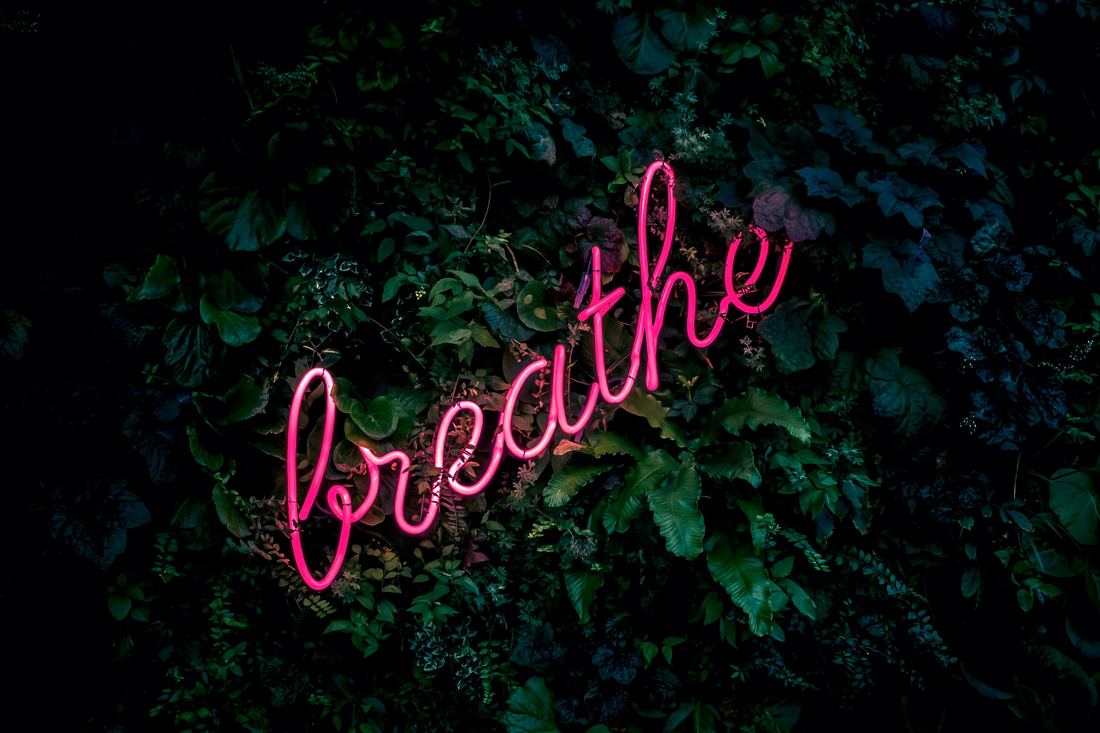 Person breathing deeply outdoors, practicing mindfulness to create personal change