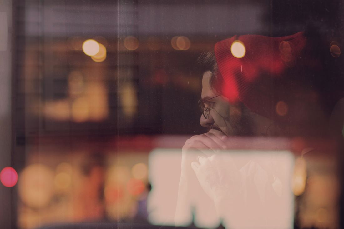 Person sitting quietly, observing anxious thoughts with mindful distance