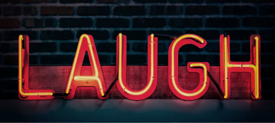 neon sign with the word "laugh"
