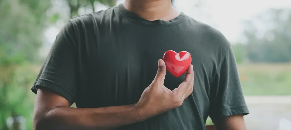 man holding a heart over his chest