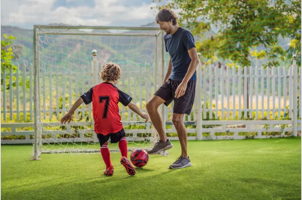 Parent playing soccer with son