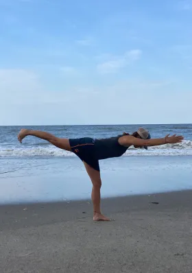 Dr. Jamie Robbins doing yoga on the beach.