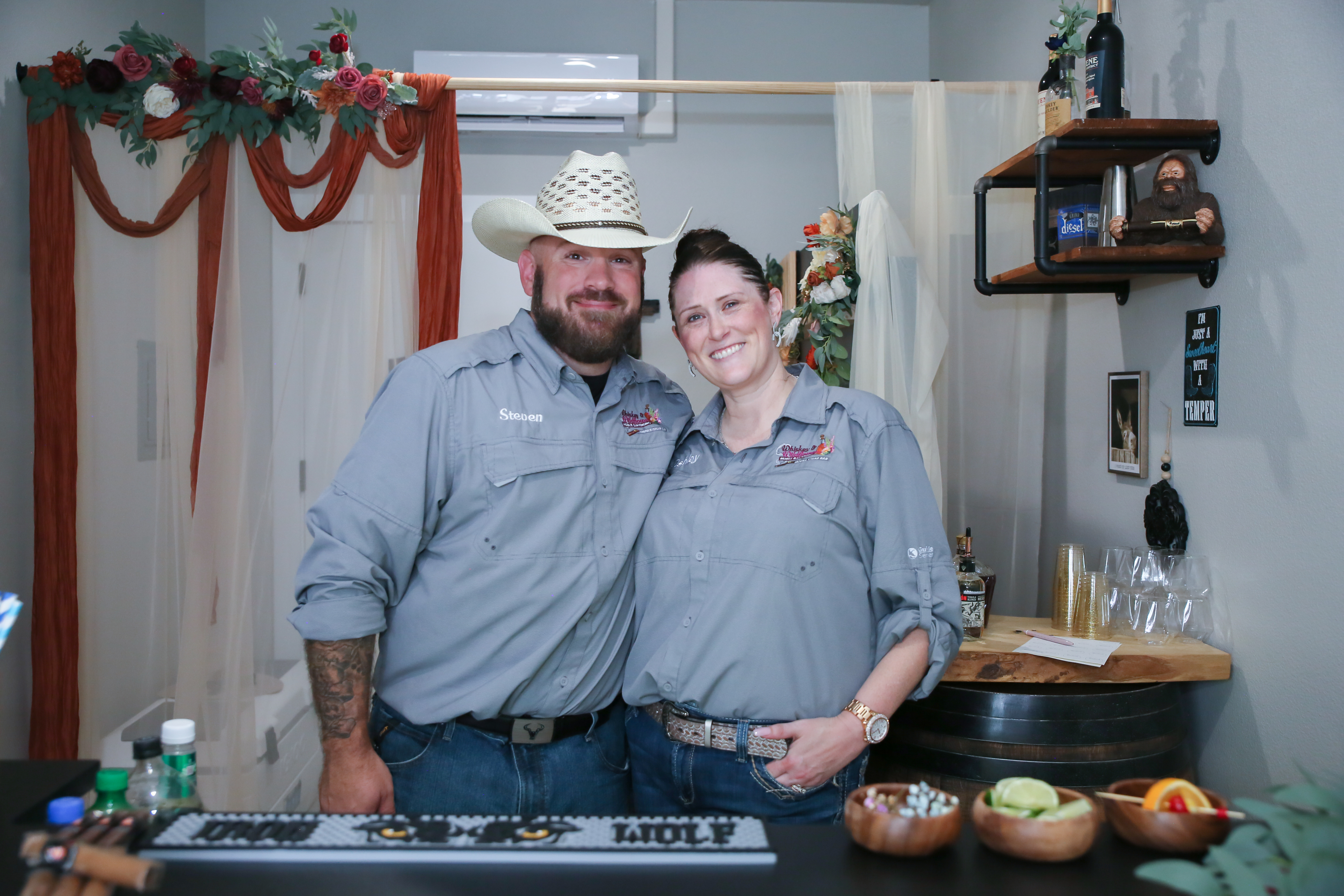 Mobile bartending and mobile cigar bar service at a wedding reception featuring a rustic bar, premium spirits, and professional event staff.