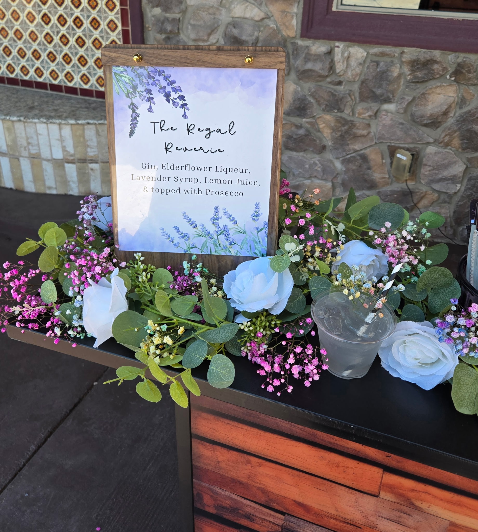 Custom wedding bar sign framed with a floral wreath on the mobile bar counter