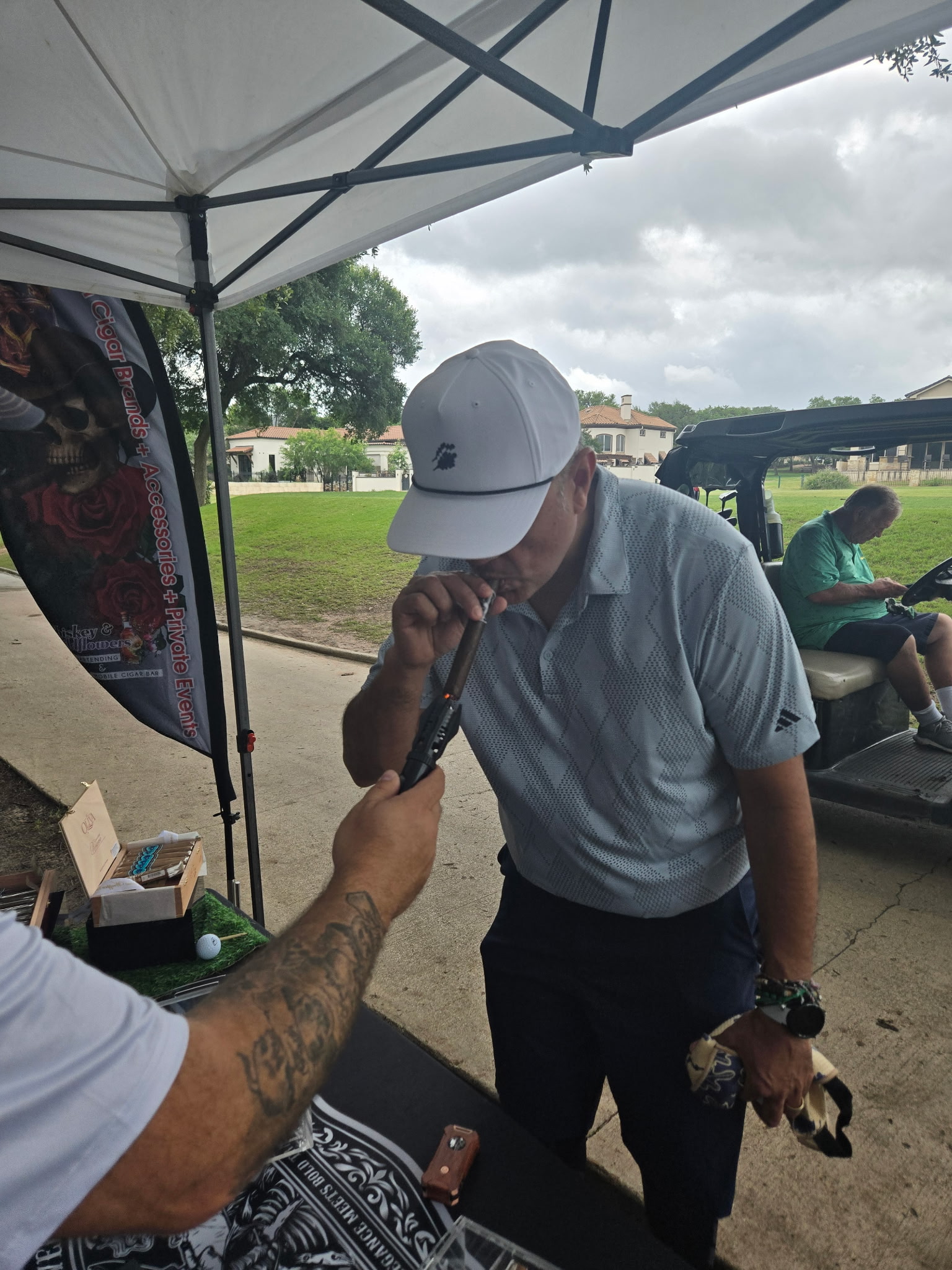 Cigar bar attendant lighting a cigar for a guest at a golf tournament event
