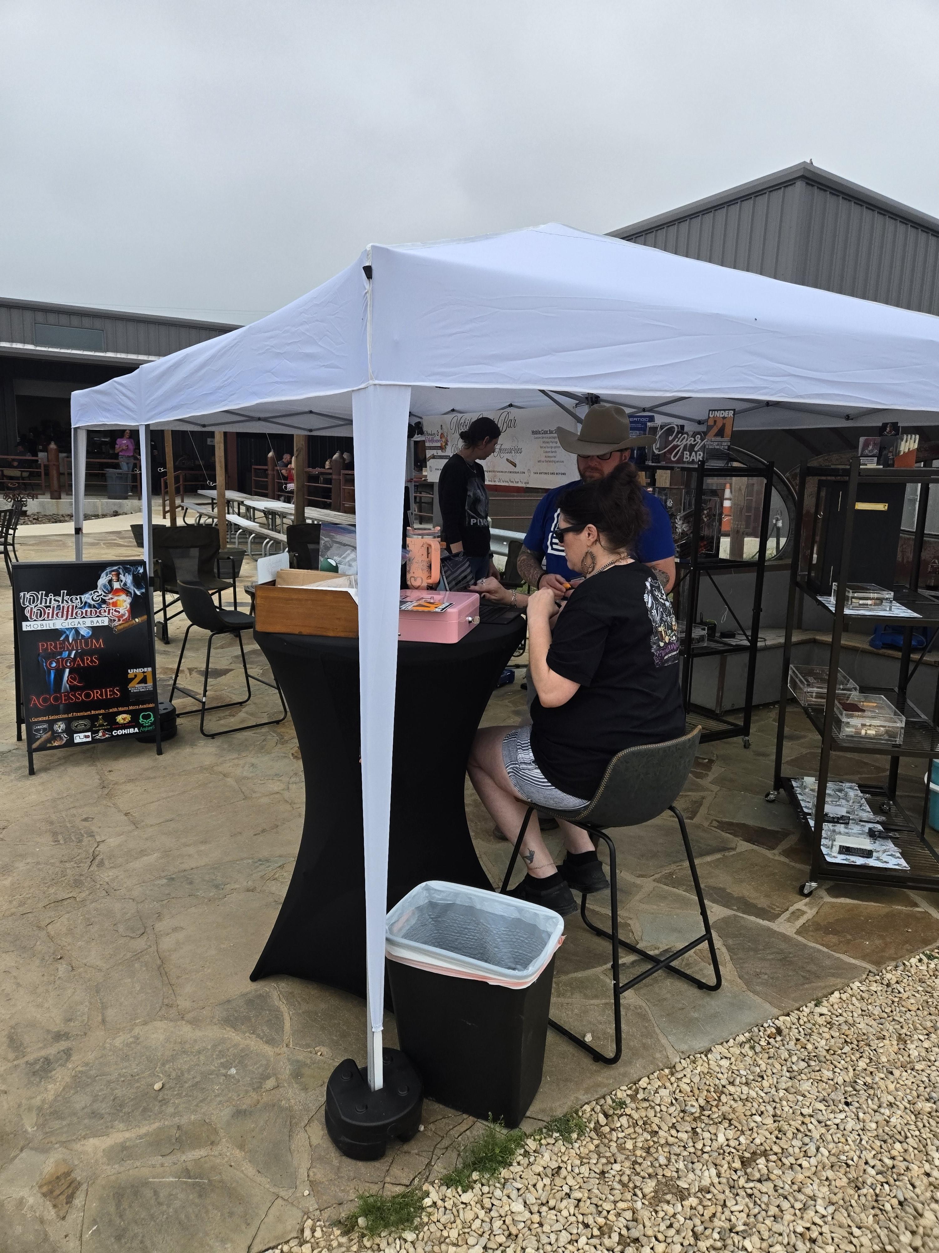 IStaff and customer at the Whiskey and Wildflowers cigar bar checkout table