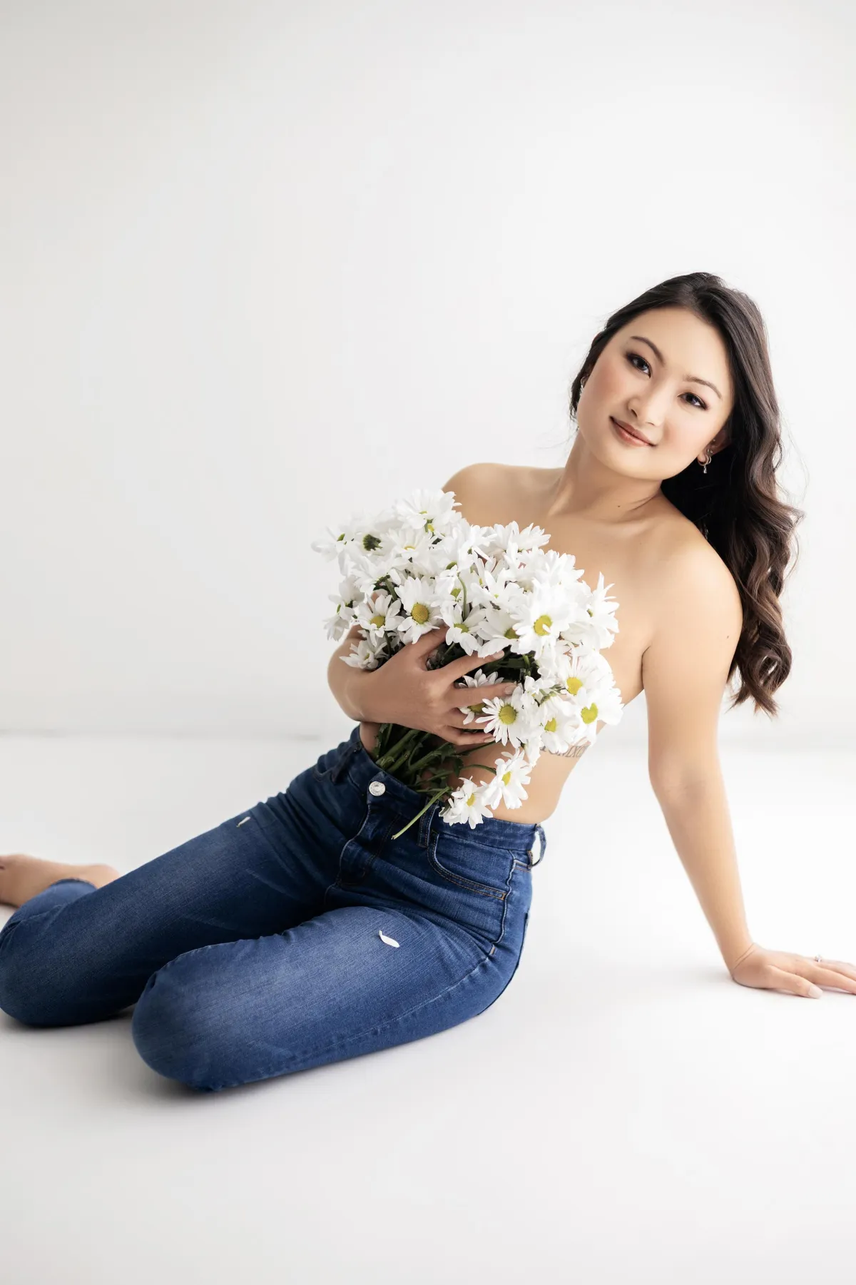 Minneapolis Boudoir woman posing with flowers in front of chest