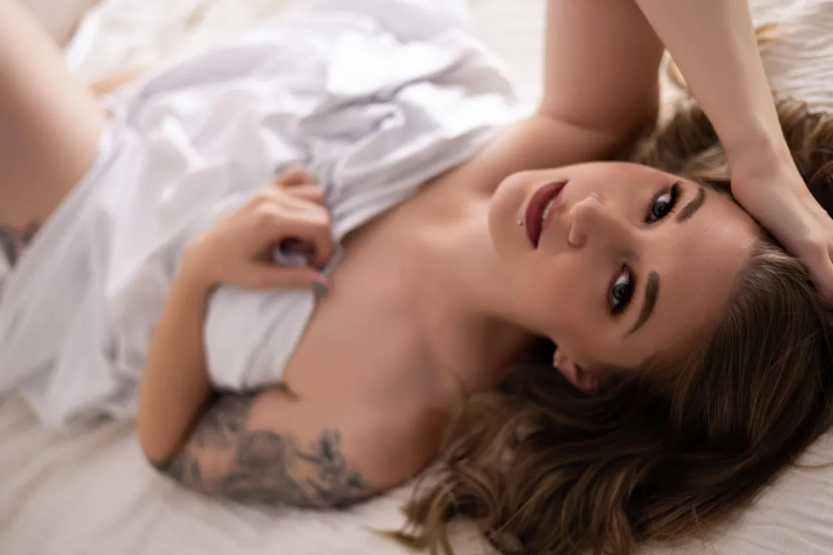 Minneapolis Boudoir woman laying on back with white sheet