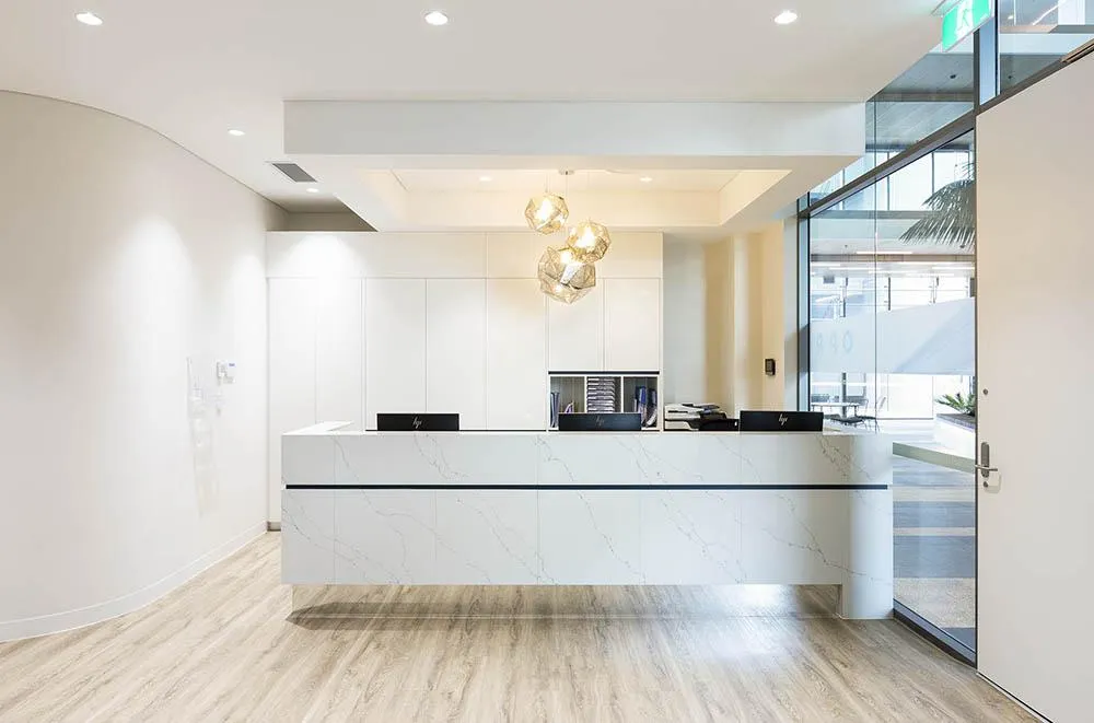 clean white and modern styled dentist reception desk fit out
