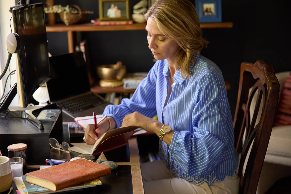 Maris Pasquale Doran writing at her desk, head down, absorbed.