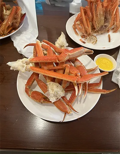 Plate with crab legs served alongside a small bowl of melted butter