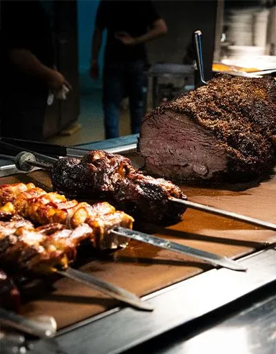 Sliced roasted meat and skewers displayed at the carving station