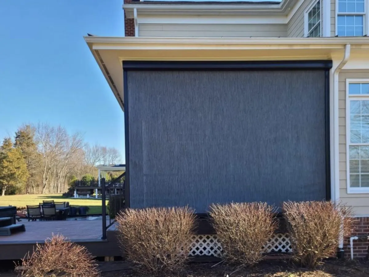 ALD Functional Living Outdoors,  A photo of Three Motorized Hurricane Defender Screens.  The housing located on the top is white and so are the tracks.  Screens are black. 