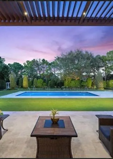 a photo of a gray and white pergola.  The roof louvers are gray,